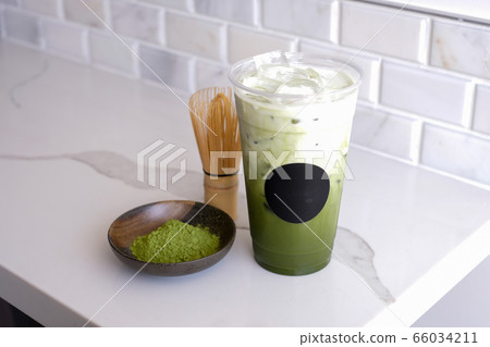 Green tea latte with ice in a plastic cup and straw and spoon with powder  matcha on yellow background. Homemade Iced Matcha Latte Tea with Milk zero  Stock Photo - Alamy