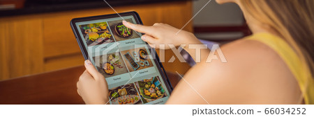 Young woman orders food for lunch online using Tablet BANNER, LONG FORMAT Young woman orders food for lunch online using Tablet BANNER, LONG FORMAT 66034252