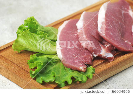 raw pork steak - pork neck - with lettuce leaves raw pork steak - pork neck - with lettuce leaves 66034966
