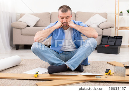 Man Sitting Near Disassembled Shelf Having Problems Installing Furniture Indoor Man Sitting Near Disassembled Shelf Having Problems Installing Furniture Indoor 66035467