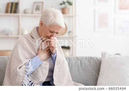 Sick Senior Woman Covered In Blanket Coughing Hard At Home Sick Senior Woman Covered In Blanket Coughing Hard At Home 66035494