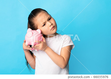 Little girl with piggy bank, studio shot, copy space Little girl with piggy bank, studio shot, copy space 66035976