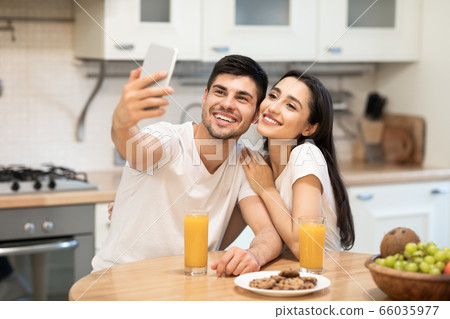 Couple taking selfie together in kitchen at home 66035977