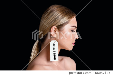 Fight for own rights concept. Housewife a label hangs on girl ear Fight for own rights concept. Housewife a label hangs on girl ear 66037123