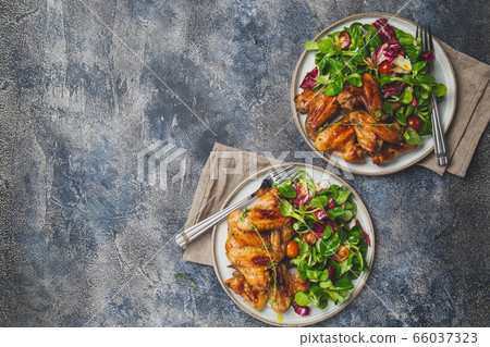 Roasted bbq wings with green salad with tomatoes. Top view Roasted bbq wings with green salad with tomatoes. Top view 66037323