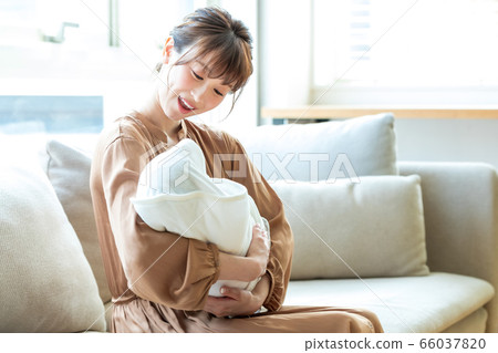 Mom holding an infant Mom holding an infant 66037820