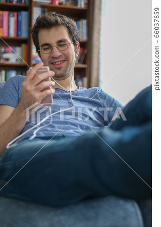 Young man communicating with his friend on a smart Young man communicating with his friend on a smart 66037859