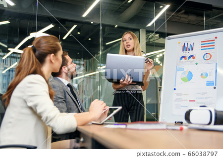 Business meeting. Business people in formalwear discussing something while sitting together at the table 66038797