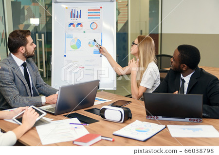 Business meeting. Business people in formalwear discussing something while sitting together at the table 66038798