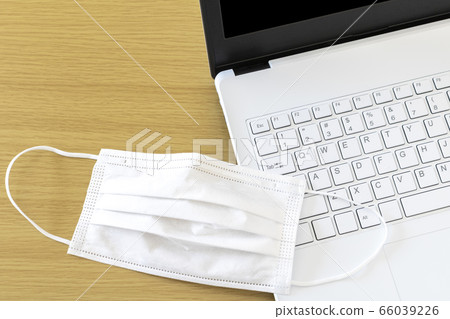 桌上的白色面具的筆記本電腦 66039226