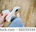 A pair of feet wearing blue and white shoes 66039344