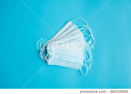 Medical protective masks on a blue background. Disposable 3-ply medical mask to cover the mouth and nose to prevent coronavirus. Coronavirus quarantine. Antivirus medical mask for protection covid-19. Medical protective masks on a blue background. Disposable 3-ply medical mask to cover the mouth and nose to prevent coronavirus. Coronavirus quarantine. Antivirus medical mask for protection covid-19. 66039998