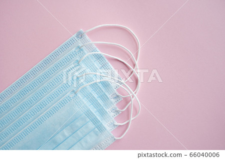 Medical protective masks on a pink background. Disposable 3-ply medical mask to cover the mouth and nose to prevent coronavirus. Coronavirus quarantine. Antivirus medical mask for protection covid-19. 66040006