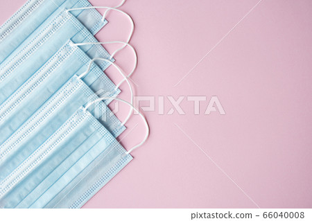 Medical protective masks on a pink background. Disposable 3-ply medical mask to cover the mouth and nose to prevent coronavirus. Coronavirus quarantine. Antivirus medical mask for protection covid-19. 66040008