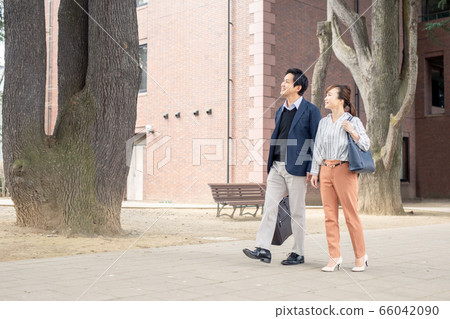 Asian male and female office workers walking in the city Asian male and female office workers walking in the city 66042090
