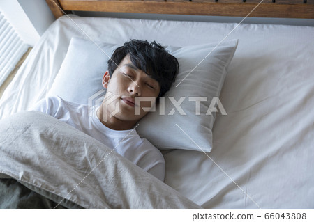 Young man sleeping in bed Young man sleeping in bed 66043808