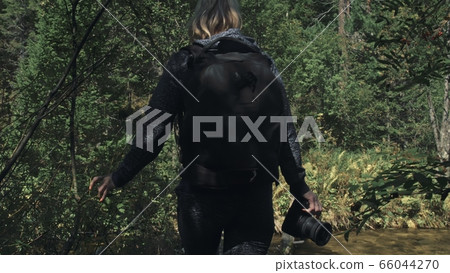 Traveler photographing scenic view in forest river. Wood bridge fallen tree. One caucasian woman shooting nice magic look. Girl take photo on camera. 66044270