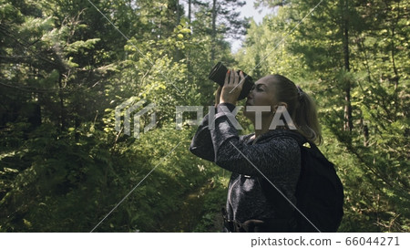 Traveler photographing scenic view in forest. One caucasian woman shooting nice magic look. Girl take photo video on dslr mirrorless camera. Traveler photographing scenic view in forest. One caucasian woman shooting nice magic look. Girl take photo video on dslr mirrorless camera. 66044271