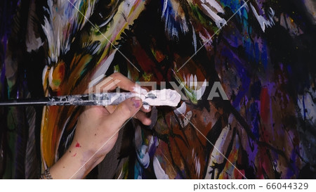 Artist designer draws an eagle on the wall. Craftsman decorator paints a picture with acrylic oil color brush. Close-up dark magic cinematic look. Artist designer draws an eagle on the wall. Craftsman decorator paints a picture with acrylic oil color brush. Close-up dark magic cinematic look. 66044329