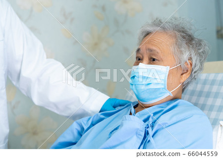 Doctor using stethoscope to checking Asian senior woman patient wearing a face mask in hospital. 66044559