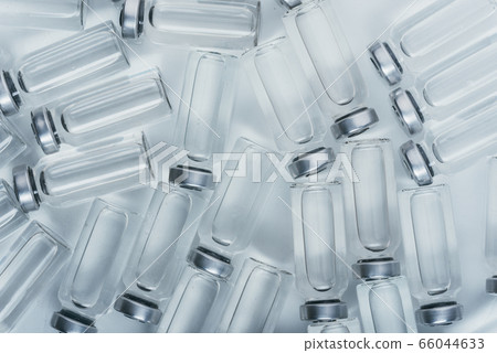 Glass medical ampoule vial for injection. Medicine is dry white drug penicillin powder or liquid with of aqueous solution in ampulla. Close up. Glass medical ampoule vial for injection. Medicine is dry white drug penicillin powder or liquid with of aqueous solution in ampulla. Close up. 66044633