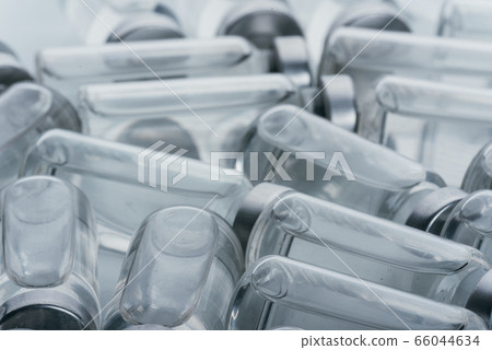 Glass medical ampoule vial for injection. Medicine is dry white drug penicillin powder or liquid with of aqueous solution in ampulla. Close up. Glass medical ampoule vial for injection. Medicine is dry white drug penicillin powder or liquid with of aqueous solution in ampulla. Close up. 66044634