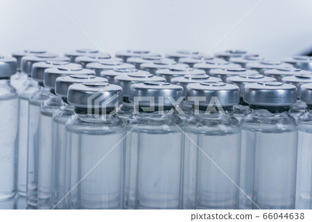 Glass medical ampoule vial for injection. Medicine is dry white drug penicillin powder or liquid with of aqueous solution in ampulla. Close up. Glass medical ampoule vial for injection. Medicine is dry white drug penicillin powder or liquid with of aqueous solution in ampulla. Close up. 66044638