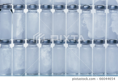 Glass medical ampoule vial for injection. Medicine is dry white drug penicillin powder or liquid with of aqueous solution in ampulla. Close up. 66044654