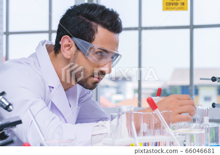 Doctor microbiologist with vacuum tubes for samples with COVID 19 infection atypical pneumonia virus 66046681