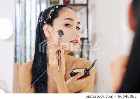 Woman applying pressed powder 66046868