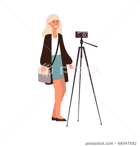 Young cute caucasian woman or girl photographer makes a photo with a camera on a tripod. 66047092