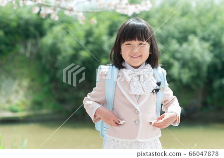 A new first grader girl dressed up and laughing 66047878