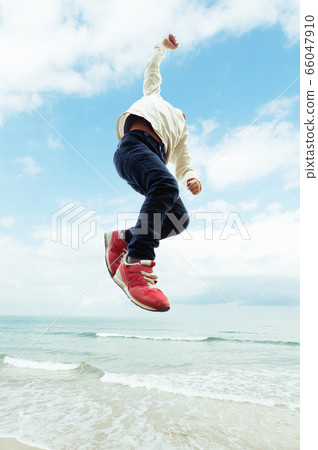 Boy jumping on the beach Boy jumping on the beach 66047910