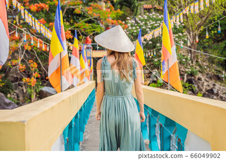 Young woman tourist in a traditional Vietnamese hat travels to Vietnam 66049902