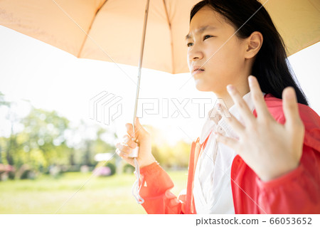 Child girl is holding umbrella uv protection from sunlight ray,high temperature on sunny day,prevent heatstroke,face skin from bright sun,sunburn very hot,using umbrella to cover the strong sun light Child girl is holding umbrella uv protection from sunlight ray,high temperature on sunny day,prevent heatstroke,face skin from bright sun,sunburn very hot,using umbrella to cover the strong sun light 66053652