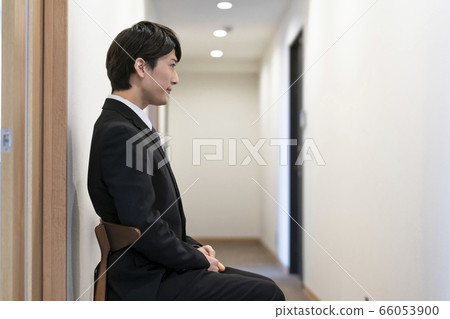 一個年輕人在走廊裡等待面試的求職/考試的圖像 66053900
