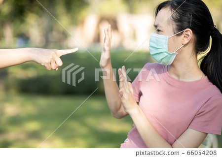 Sad asian girl student in hygienic mask during the pandemic of Coronavirus or Covid-19,hand pointing finger to scared child girl,bullying victim and hate,anti racism,stop xenophobia,bullied by society 66054208