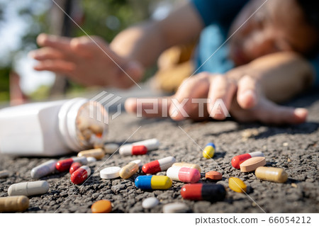 Asian man with illness and acute heart disease,male is suffering from heart attack fell down on the street trying to reach for the medicine bottle,lot of pills,tablets and capsules fallen at the floor Asian man with illness and acute heart disease,male is suffering from heart attack fell down on the street trying to reach for the medicine bottle,lot of pills,tablets and capsules fallen at the floor 66054212