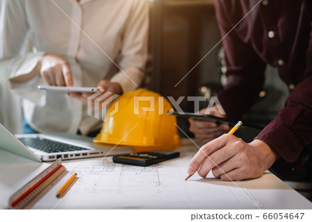 Person's engineer Hand Drawing Plan On Blue Print with architect equipment, Architects discussing at the table, team work and work flow construction concept. Person's engineer Hand Drawing Plan On Blue Print with architect equipment, Architects discussing at the table, team work and work flow construction concept. 66054647