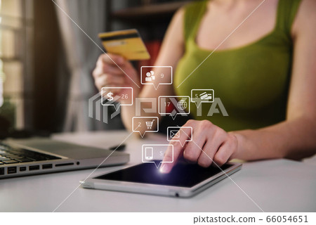 Female shopping online with her credit card and a tablet computer at home. Female shopping online with her credit card and a tablet computer at home. 66054651