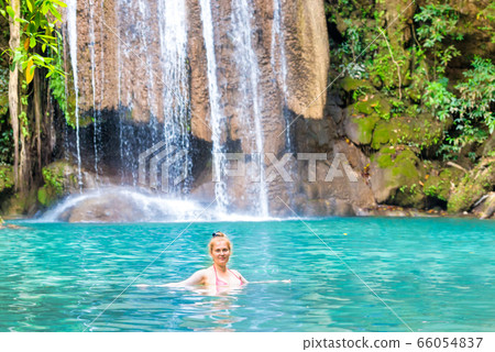Young woman relaxes in emerald blue lake, Erawan 66054837