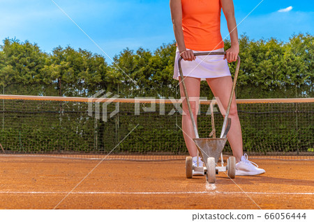 drawing white lines with lime. maintenance and repair of tennis courts. copy space 66056444