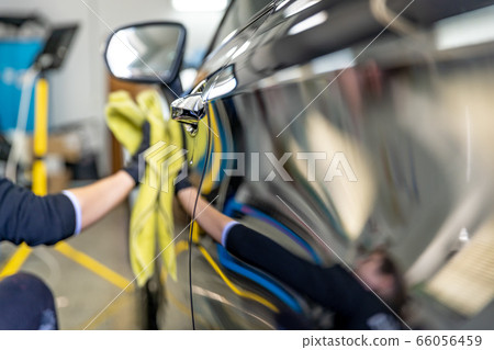 polishing the body of luxury cars with the help of a microfiber cloth for a perfect shine. hand wash luxury cars 66056459