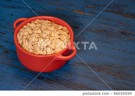 oatmeal with nuts in a mug on a blue wooden background oatmeal with nuts in a mug on a blue wooden background 66056894