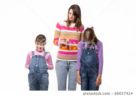 Mom scolds children, one girl smiles another 66057424