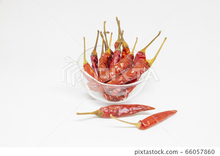 dried red chillies in a glass cup on a white 66057860