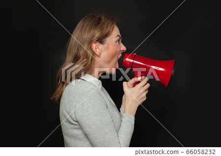 Angry woman screaming with loudspeaker megaphone 66058232
