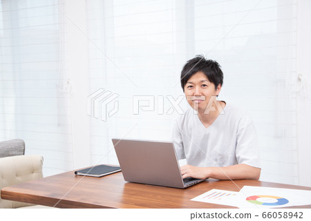 一個年輕人在做遠程辦公 一個年輕人在做遠程辦公 66058942