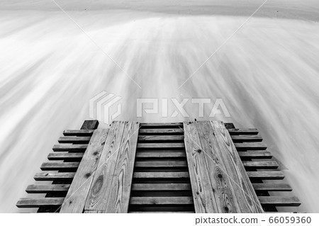 A breaking pier and surf washed out with a long 66059360