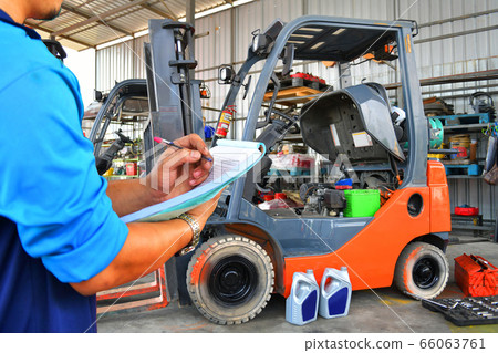 The mechanic is checking the quality and Maintenance Forklift,Energy fuel concept. 66063761